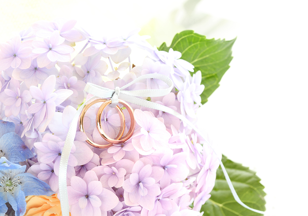 紫陽花モチーフのリングピローにゴールドの結婚指輪が置かれている