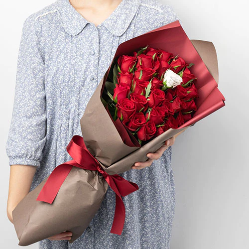 プロポーズ用の赤い薔薇の花束で中に１輪だけ花びらメッセージの入った白い薔薇もある
