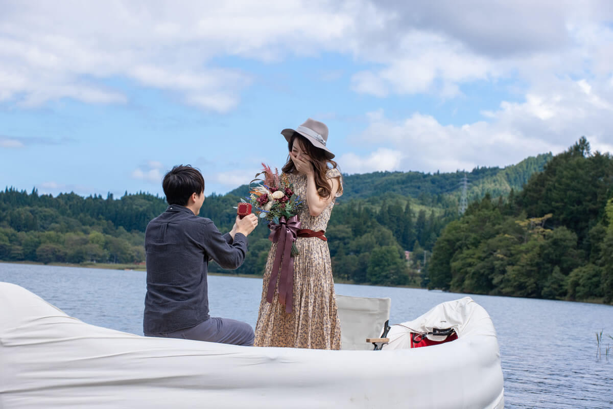 ボートの上で男性からプロポーズされて感激する女性