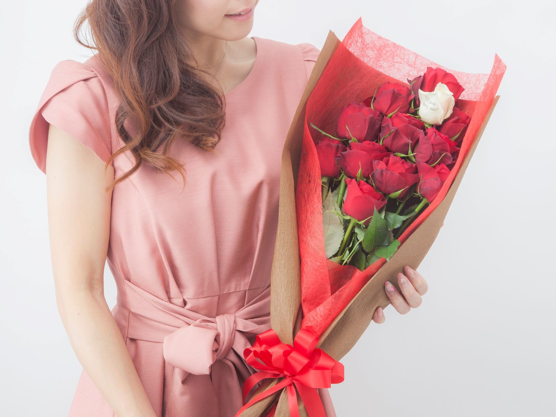 プロポーズ用のバラの花束を抱えた女性