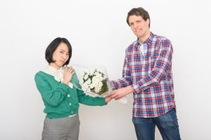 プロポーズで菊の花束を渡され不満げな女性と困り顔の男性