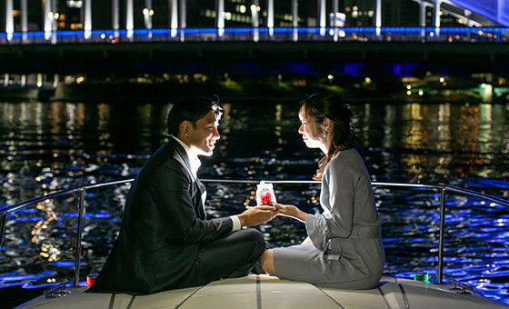 港の夜景をバックにプロポーズするカップル