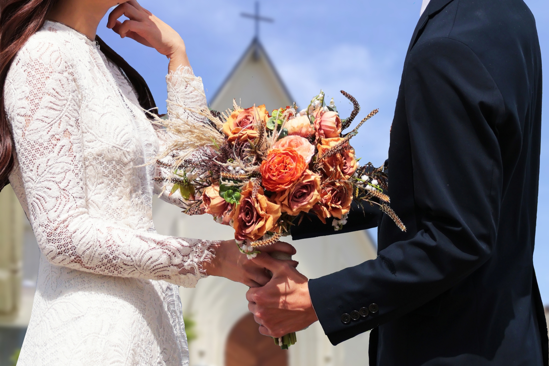 チャペルの前で花束を渡しプロポーズするカップル