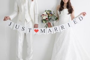 ウェディングフォトに人気のアイテムであるJUST MARRIEDのガーランドを持つ新郎新婦