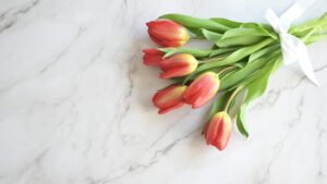 赤と黄色のチューリップを白いリボンで結んだクラッチブーケ