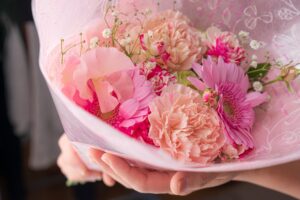 プロポーズのプレゼントとして人気のオレンジのカーネーションとピンクのガーベラ、かすみ草の花束