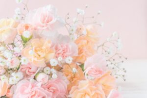 プロポーズのプレゼントとして人気の白いかすみ草とパステルピンクとオレンジのカーネーションの花束